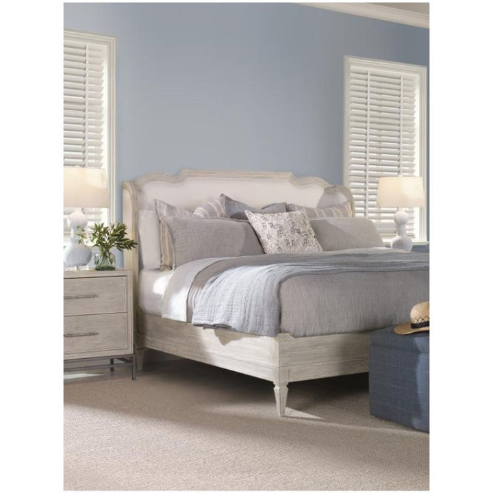 Neatly made bed with gray bedding in a bedroom setting.