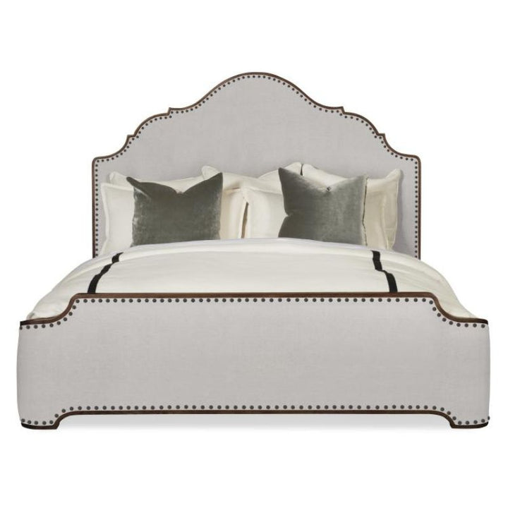 Bed with decorative headboard and pillows on a white background